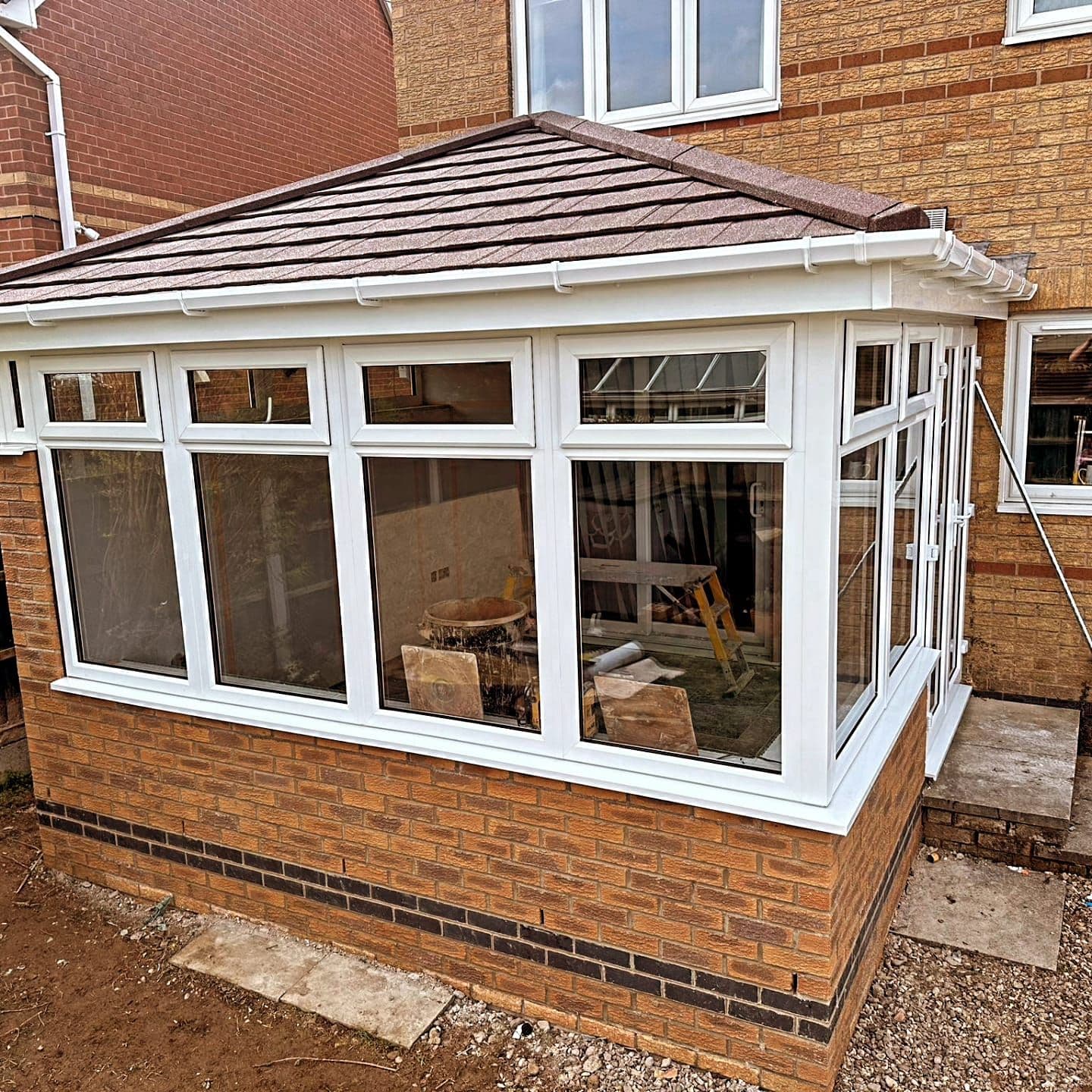 Conservatory with a new solid tiled warm roof and white frames